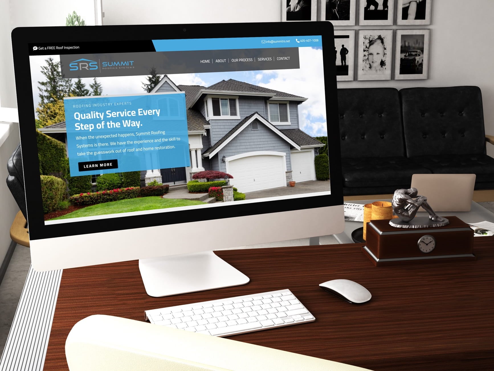 Desktop monitor showing Summit Roofing Systems website with house image, office desk, keyboard and mouse in modern office.