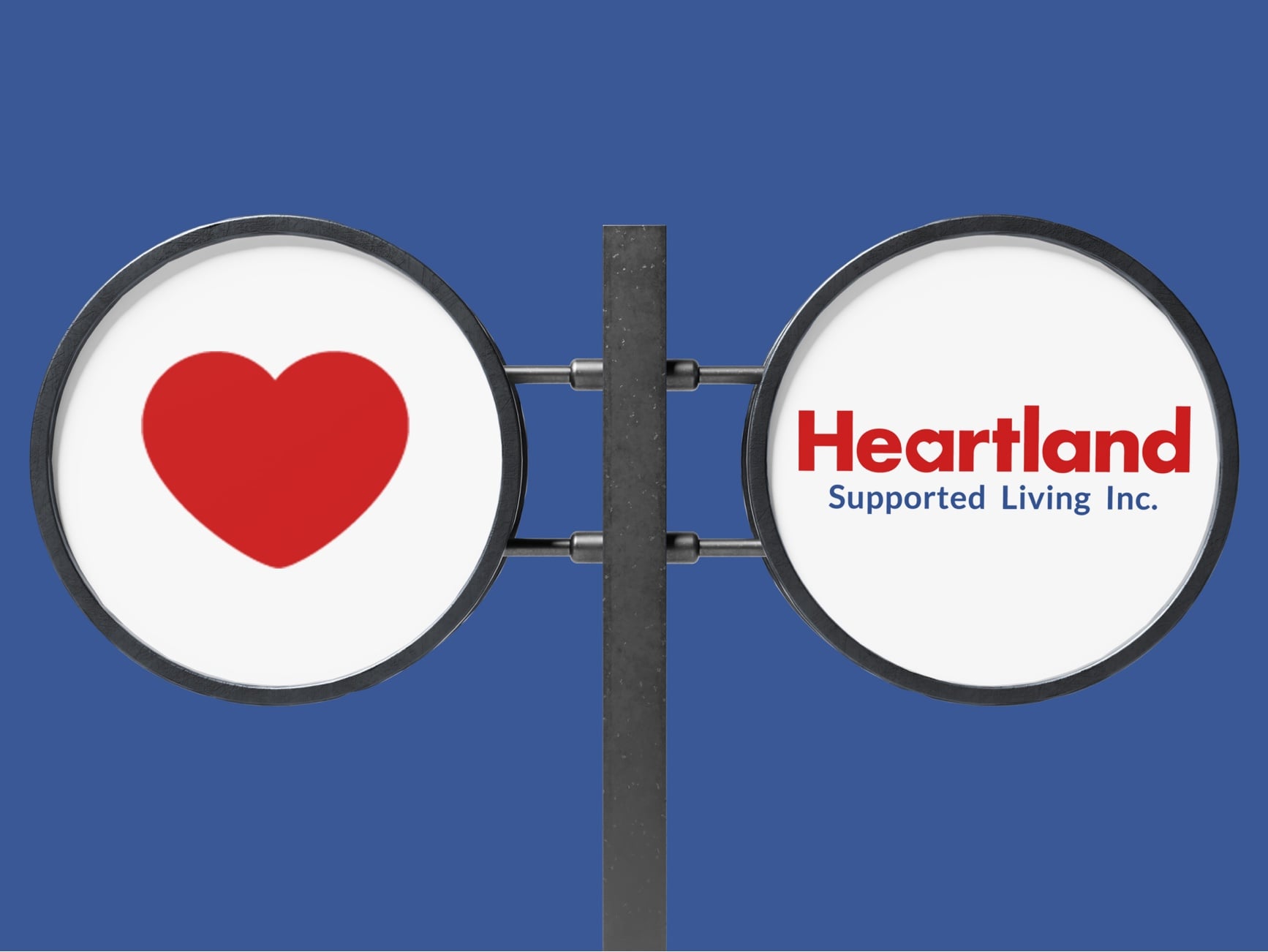 Two circular signs on a pole; left shows a red heart, right reads 'Heartland Supported Living Inc.' in red and blue.