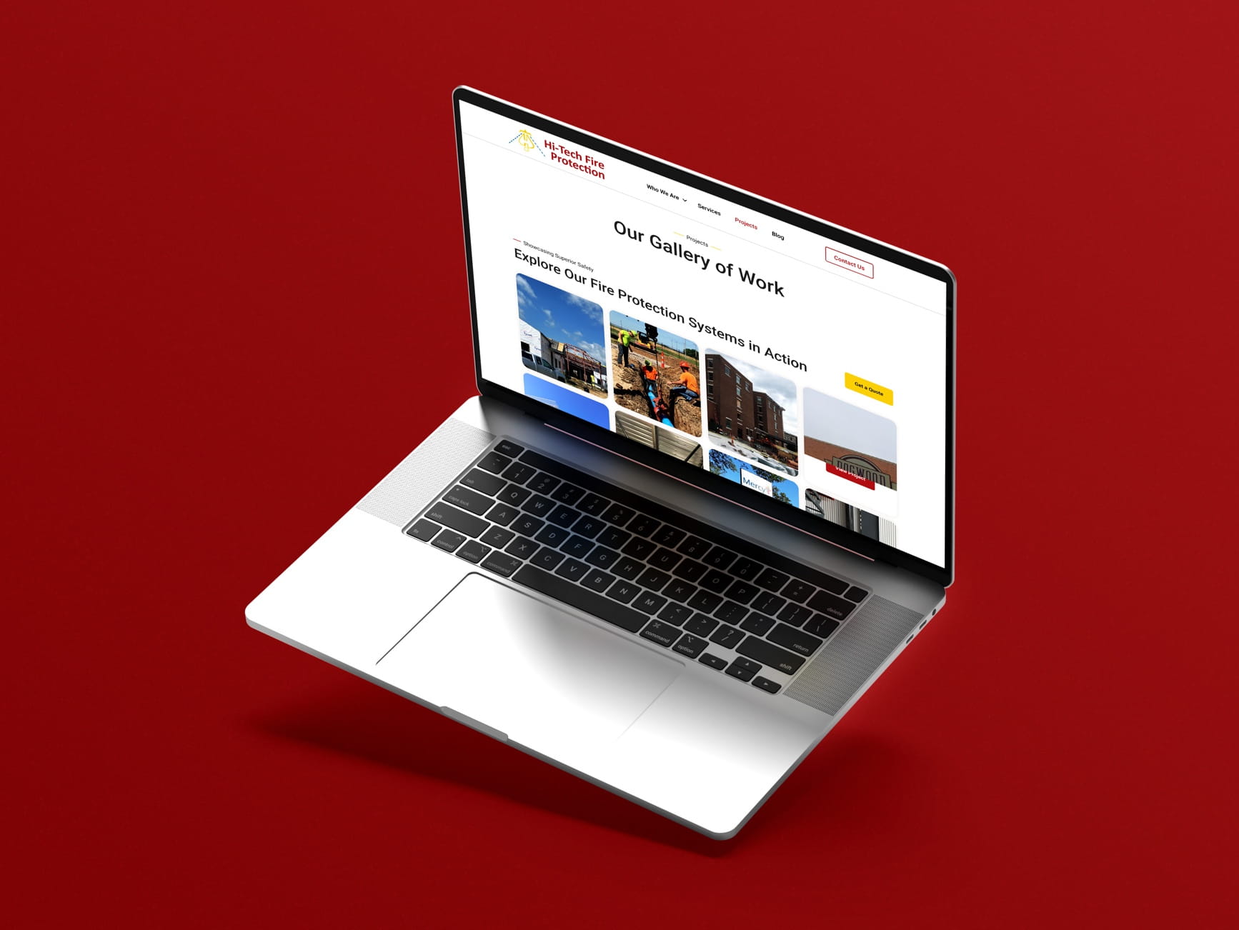 Silver laptop on red background displaying Hi-Tech Fire Protection website gallery of fire protection system projects.