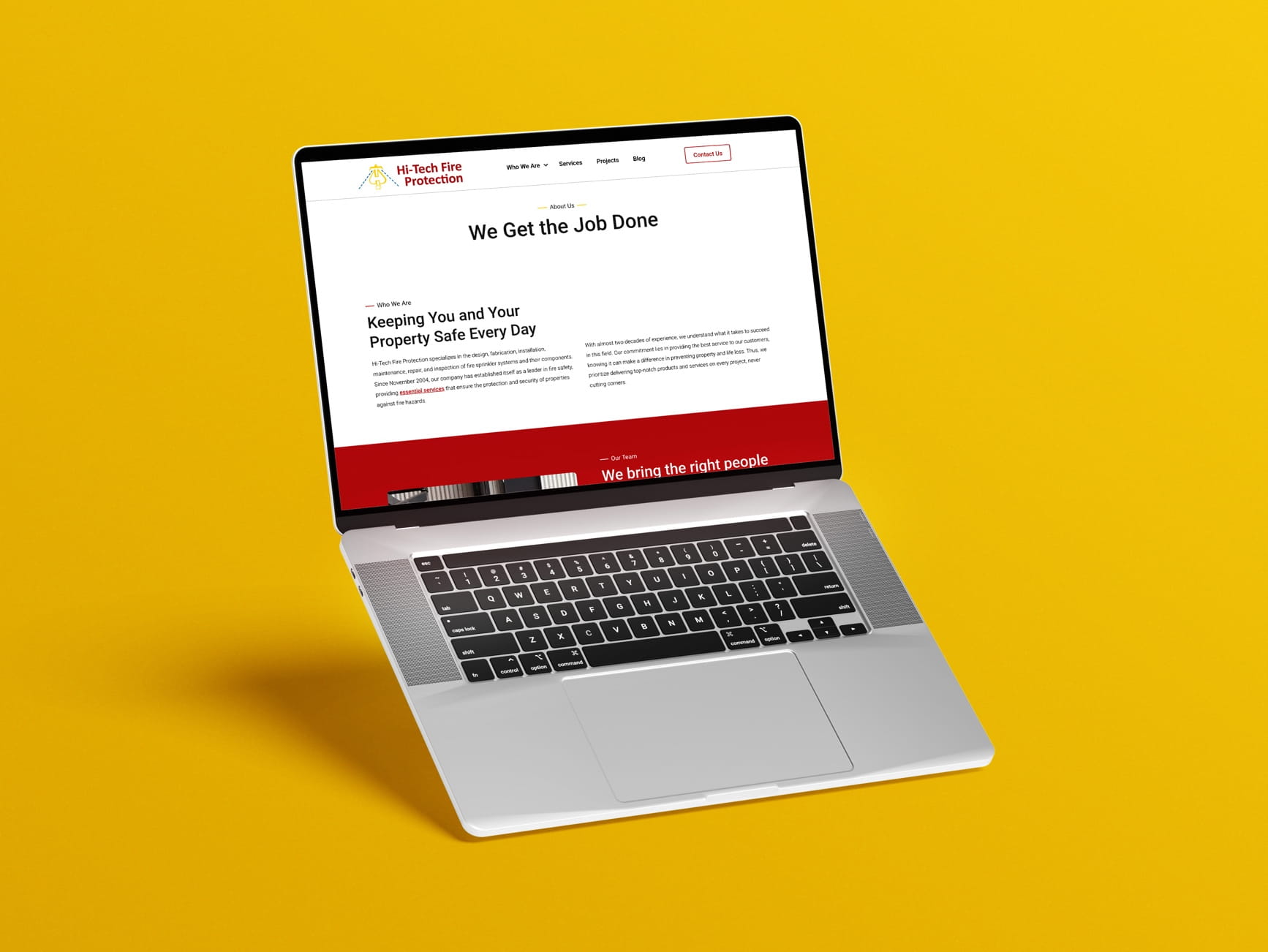 Silver laptop on yellow background displays Hi-Tech Fire Protection site with 'We Get the Job Done' headline.