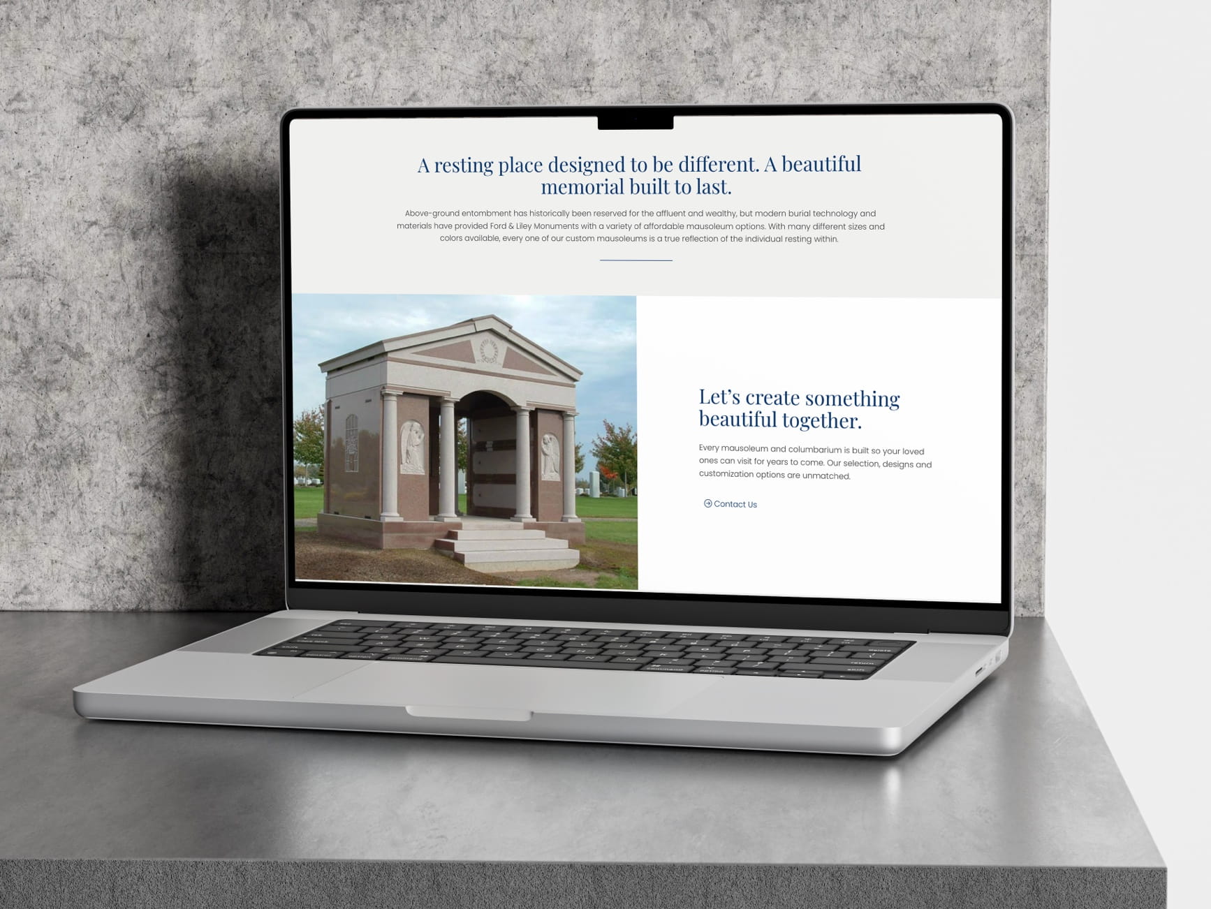 Laptop on gray surface showing a website with a mausoleum image and text about custom memorials
