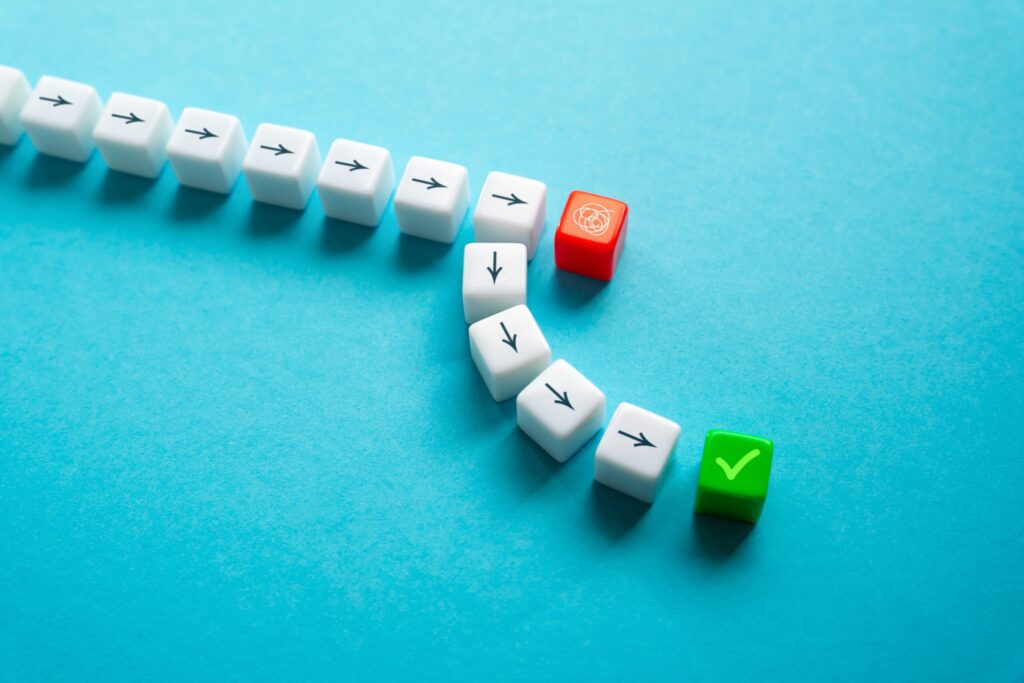 White arrow cubes lead to a red tangled cube, then down arrows, ending with a green checkmark cube on a blue surface.