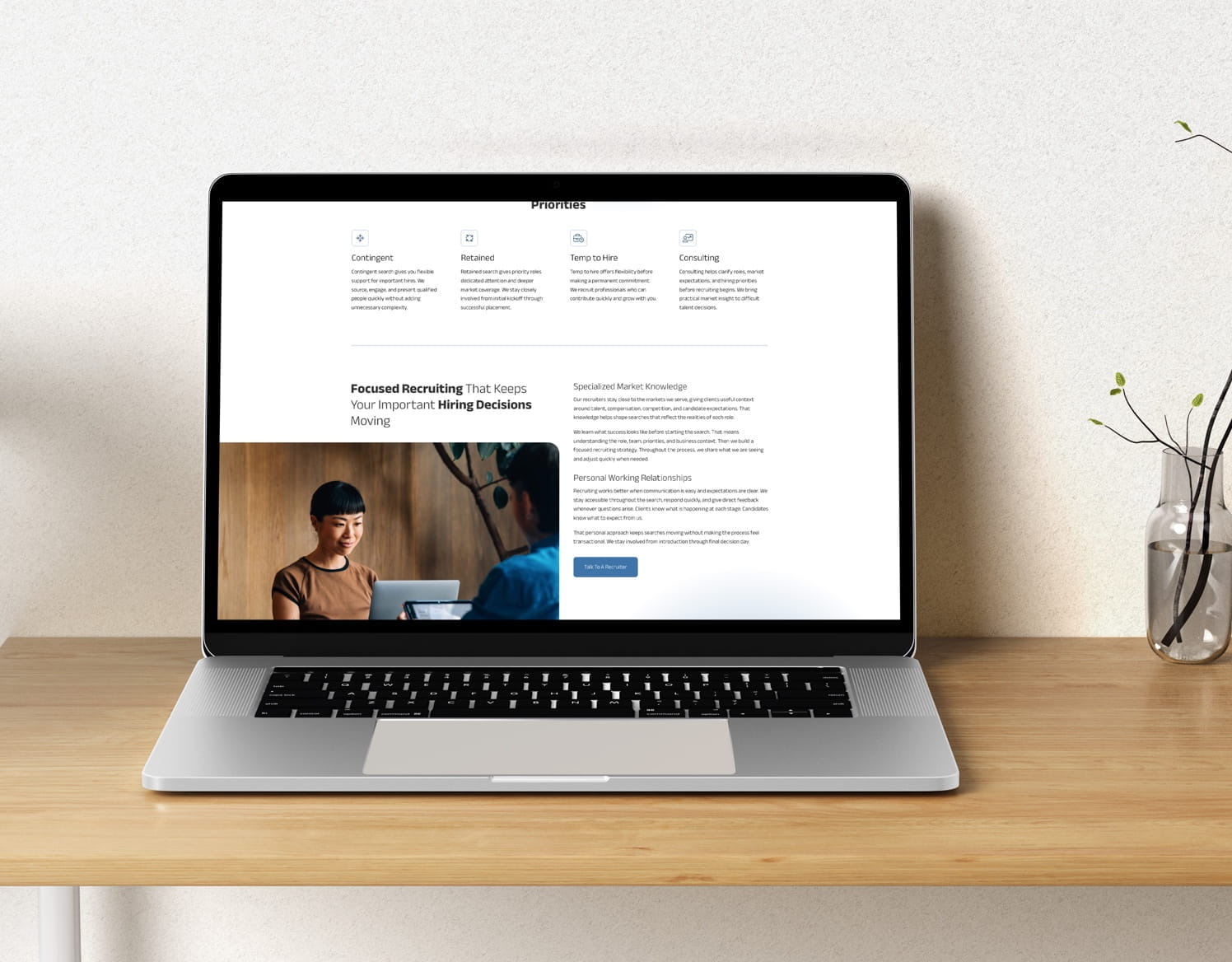 Laptop displaying a website about focused recruiting, with sections on contingent, retained, temp to hire, and consulting ser